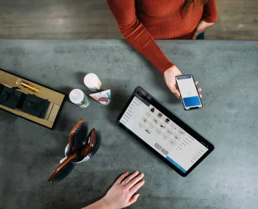 a person holding a phone and a tablet