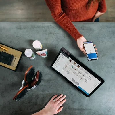 a person holding a phone and a tablet